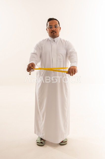 Overweight Saudi Man Measuring Waist in Studio