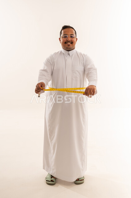 Saudi Man Measuring Waist in White Thobe Studio