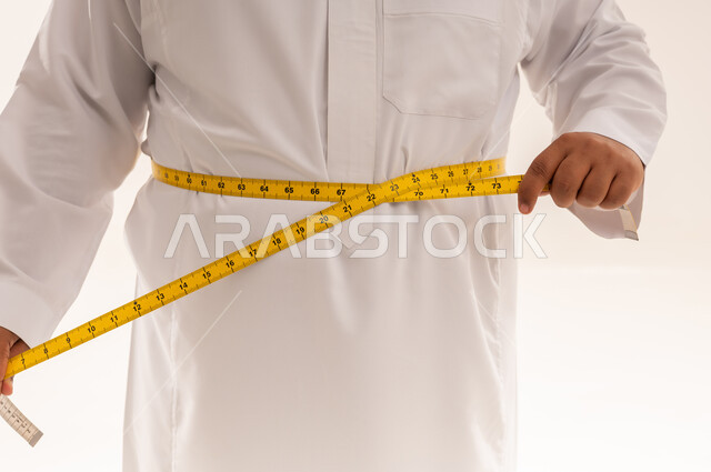 Saudi Man Measuring Waistline in White Thobe