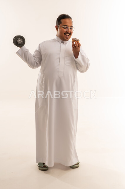 رجل سعودي مع وزن رياضي ودونات في الاستوديو