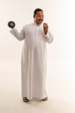 رجل سعودي مع وزن رياضي ودونات في الاستوديو