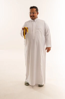 رجل سعودي يعاني من السمنة يحمل شريط قياس في الاستوديو