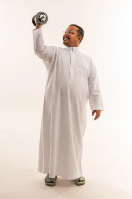رجل سعودي بالثوب يرفع الأثقال بخلفية بيضاء