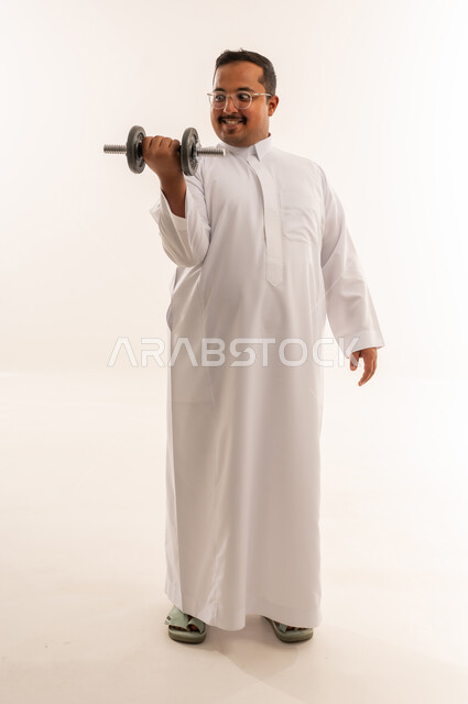 رجل سعودي بالثوب التقليدي يمارس رفع الأثقال