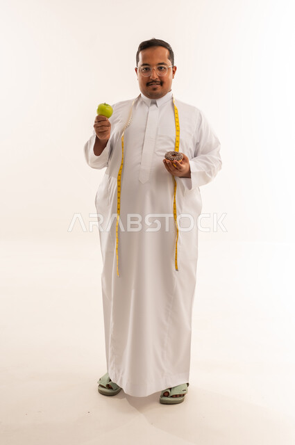 رجل سعودي يختار بين التفاحة والدونات في الاستوديو