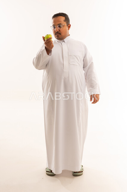 Saudi Man in Thobe Holding Green Apple Studio Shot