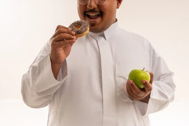 رجل سعودي يقارن بين الدونات والتفاحة الخضراء