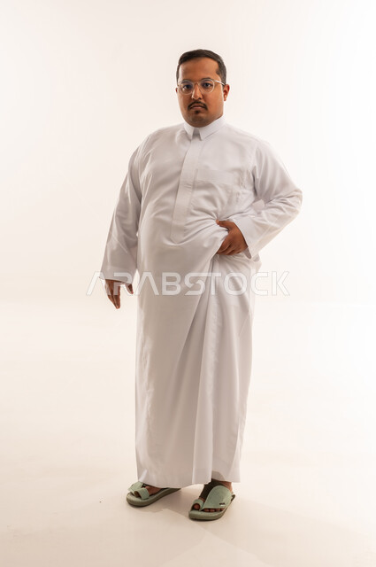 رجل سعودي يعاني من السمنة بالثوب الأبيض في الاستوديو