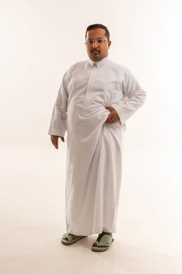 رجل سعودي يعاني من السمنة بالثوب الأبيض في الاستوديو