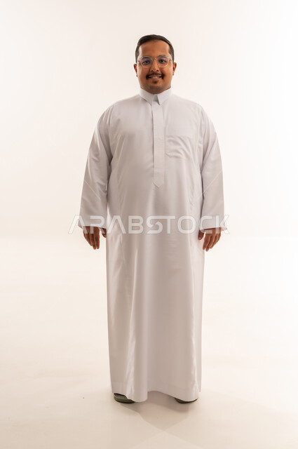 رجل سعودي بدين مبتسم بالثوب الأبيض استوديو