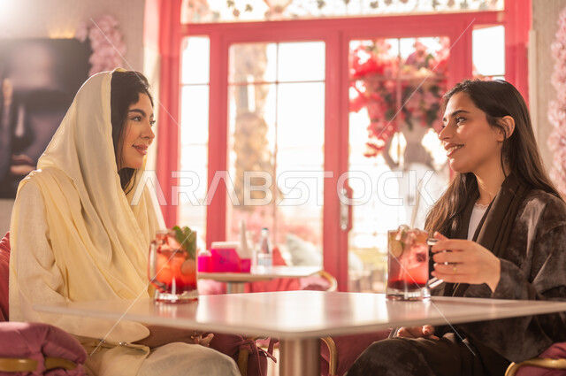 Arab Women in Abayas at Cafe with Drinks