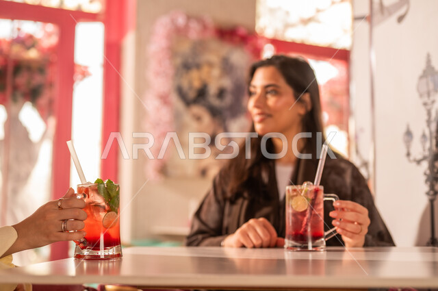 Saudi Woman in Abaya at Cafe with Cold Drink