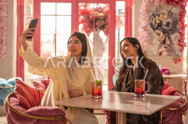 Saudi Women in Abayas Taking Selfie at Cafe
