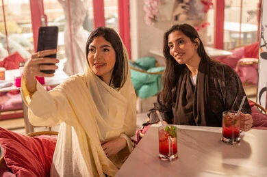 Saudi Women in Abayas Taking Selfie at Cafe