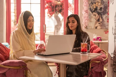 Arab Women Using Laptop in Modern Cafe Interior
