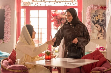 Saudi Women in Traditional Abayas Greeting in Cafe