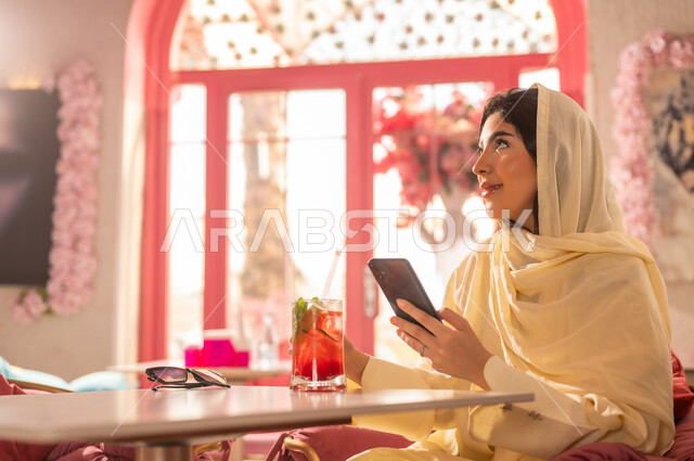 Saudi Woman with Smartphone in Pink Cafe