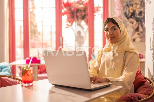 Emirati Woman Working on Laptop in Cafe