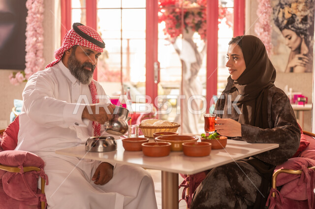 Saudi Couple in Traditional Attire Dining at Restaurant