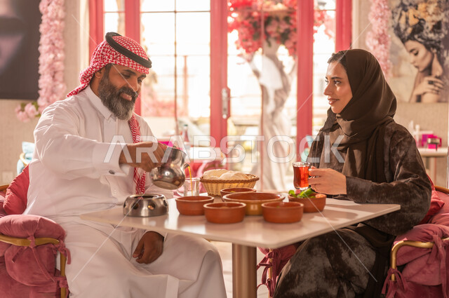 Saudi Couple in Traditional Dress Dining at Restaurant