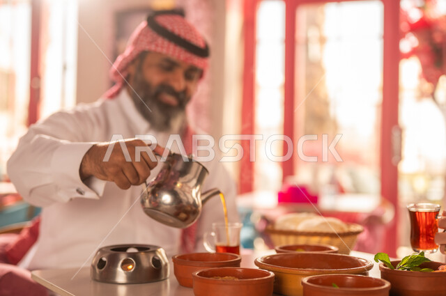 Saudi Man in Traditional Dress Pouring Tea
