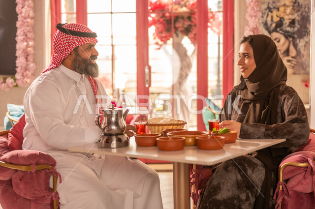 Saudi Couple in Traditional Attire Dining at Restaurant
