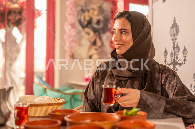 Saudi Woman in Abaya Drinking Tea at Restaurant