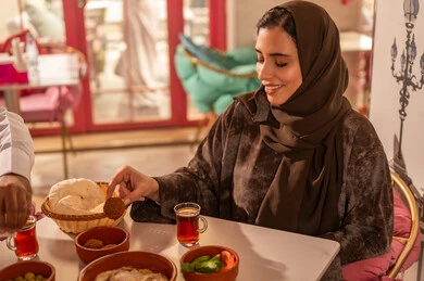 Saudi Woman Eating Traditional Breakfast in Restaurant