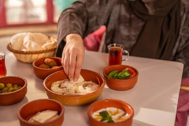 Saudi Woman Eating Traditional Arabic Breakfast with Tea