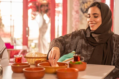 Saudi Woman Eating Traditional Breakfast in Restaurant