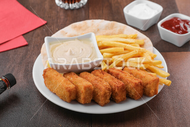 Close-up of delicious chicken nuggets with fried potatoes, Arabic meals, delicious recipes and dishes, delicious meals, Saudi Arabian Gulf restaurants