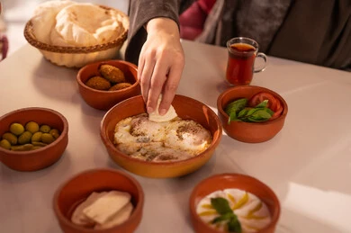Arabic Woman Eating Traditional Breakfast with Tea