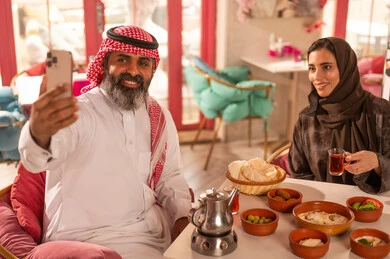 زوج سعودي يلتقط سيلفي أثناء تناول الطعام في مطعم