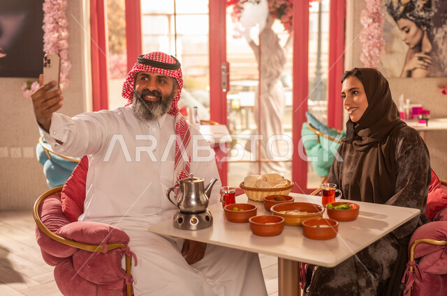 Saudi Couple Taking Selfie at Traditional Restaurant