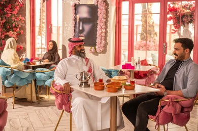 Saudi Man in Traditional Attire at a Pink Restaurant
