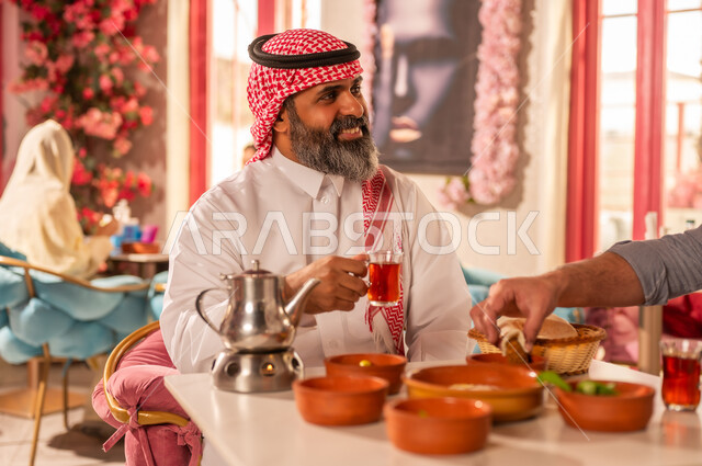 Saudi Man in Traditional Dress Having Arabic Breakfast
