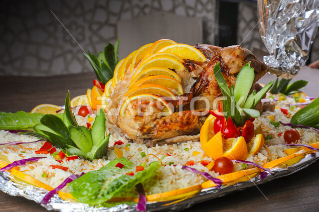 A plate of delicious grilled chicken and rice decorated with vegetables, Arabic meals, delicious recipes and dishes, delicious meals, Saudi Arabian Gulf restaurants