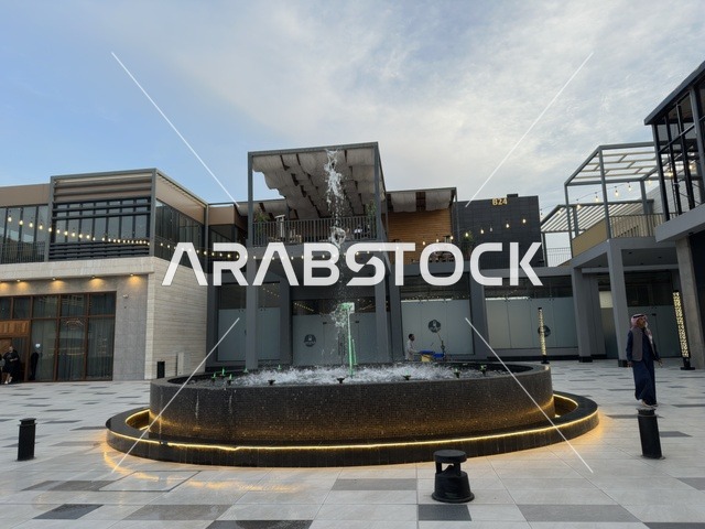 A water fountain and a modern commercial plaza in the Shurfat Park complex in Al Khobar, Saudi Arabia.