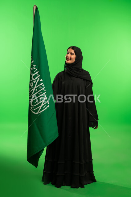 امرأة سعودية مع العلم السعودي خلفية كروما خضراء