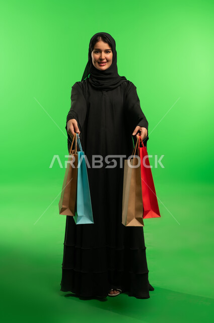 امرأة سعودية مع حقائب تسوق كروما خضراء