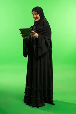 Saudi Woman in Black Abaya Using Tablet on Green Screen