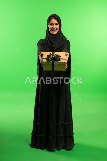 Saudi Woman in Abaya Holding Gift Box on Green Screen