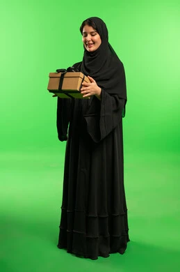 امرأة سعودية بالعباءة تحمل هدية على خلفية خضراء