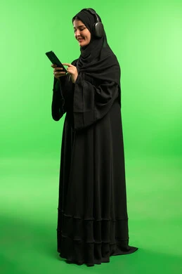 Saudi Woman Using Smartphone with Headphones on Green Screen