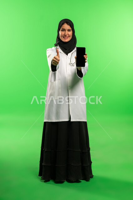 Saudi Female Doctor with Smartphone on Green Screen