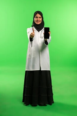 طبيبة سعودية مع هاتف ذكي أمام خلفية خضراء