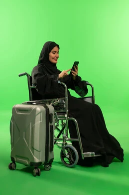 Saudi Woman in Wheelchair with Suitcase on Green Screen