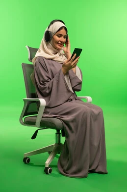 Saudi Woman with Headphones and Smartphone on Green Screen