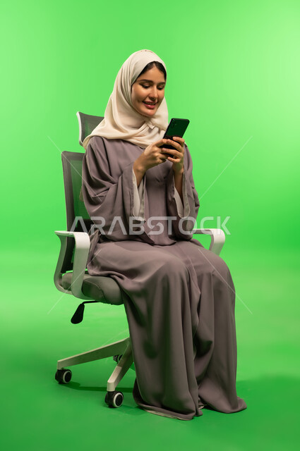 Saudi Woman in Abaya Using Smartphone on Green Screen