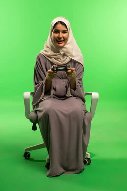 Saudi Woman Gaming with Controller on Green Screen